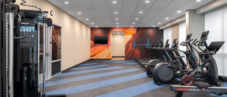 A gym with treadmills, stationary bikes, and weight machines.