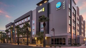 Un moderno edificio de hotel con un cartel que dice 'HOME 2 by Hilton' y 'TRU by Hilton'.