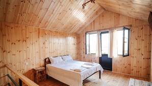 A wooden-paneled room with a bed, a small table, and a window. - Bungalow (Tbilisi)