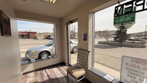 A room with a window view of a street, a chair, and a sign indicating 'NONSMOKING' and 'NO ALCOHOLIC BEVERAGES'.