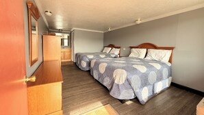 A bedroom with two beds, wooden headboards, and a wooden dresser.