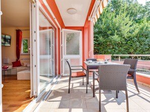 A balcony with wicker furniture, a table, and chairs. - Morski dragulj by Interhome (Vodice)