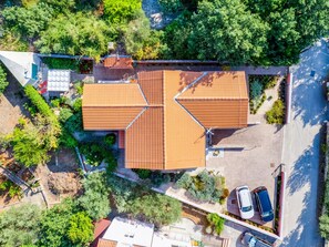 An aerial view of a house with a symmetrical roof design, surrounded by lush greenery and a parking area with two cars. - Morski dragulj by Interhome (Vodice)