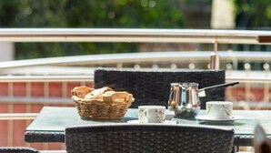 A wicker table with a basket, teapot, and cups, set on a balcony with a railing and greenery in the background. - Morski dragulj by Interhome (Vodice)