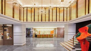 A spacious lobby with a reception desk, a staircase, and a large sculpture. - Howard Johnson by Wyndham Life Kunming Guandu Hotel (Kunming)