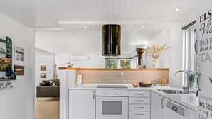 A modern kitchen with white cabinetry, a wooden countertop, and a built-in oven.