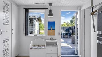 Une cuisine moderne avec des meubles blancs, une fenêtre et une vue sur l’extérieur.