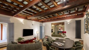 Amplia sala de estar con un televisor de pantalla plana grande, una mesa de comedor redonda y un sofá seccional acogedor.