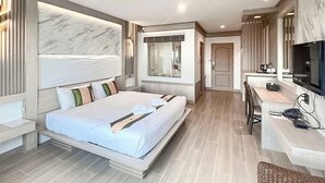 A modern hotel room with a large bed, a desk, a TV, and a shower. - Ruean Phae Royal Park Hotel (Phitsanulok)
