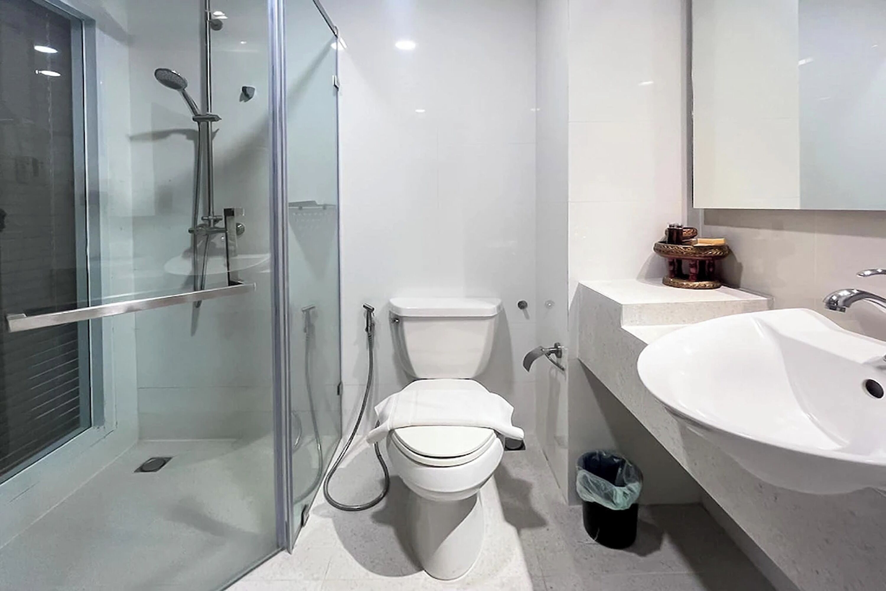 Un baño moderno con ducha de vidrio, inodoro y lavabo.