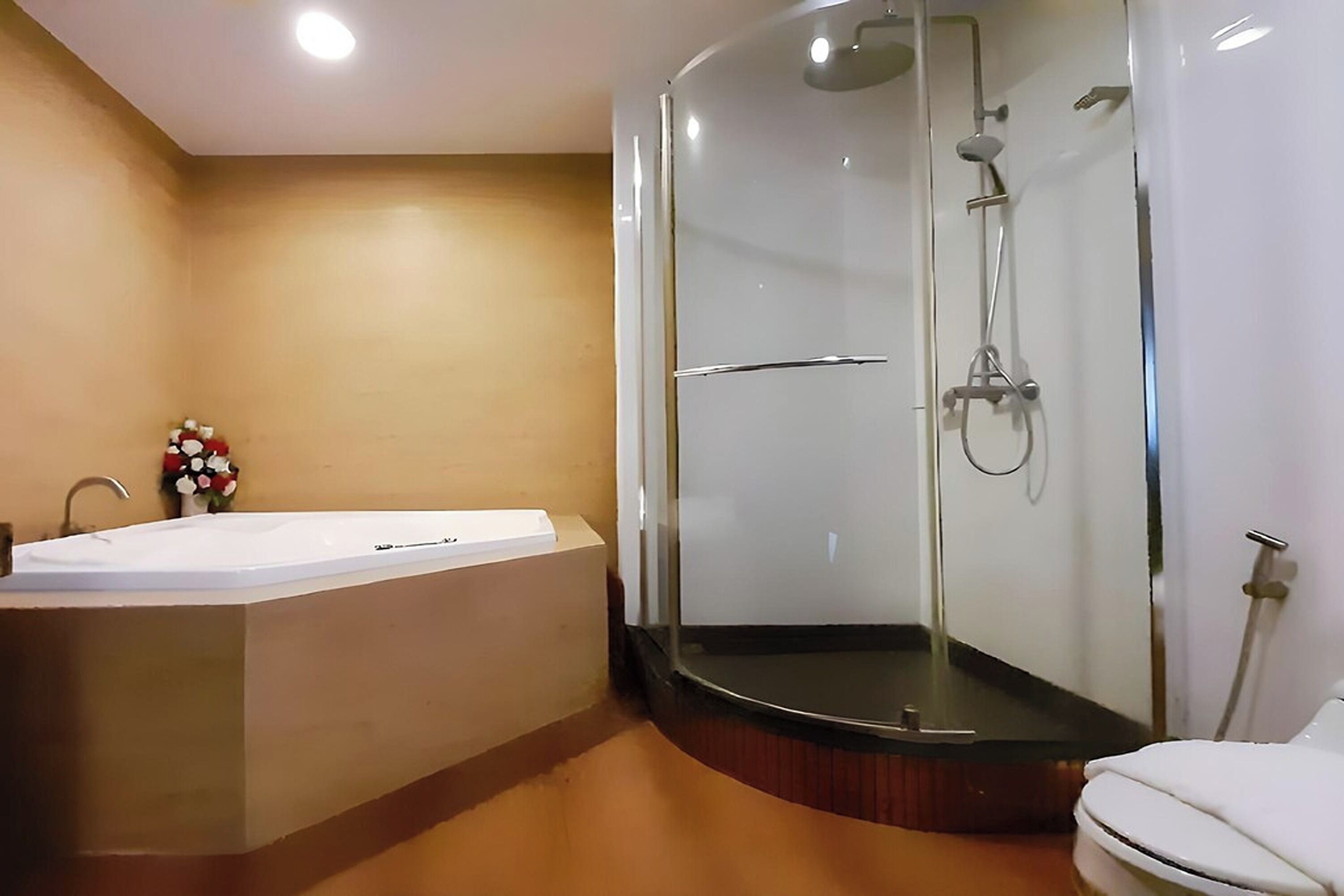 Un bagno moderno con doccia in vetro, una vasca da bagno indipendente e un WC.