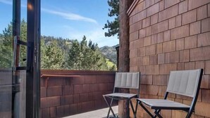 A balcony with two chairs and a wooden wall. - Palisades Condo – Walk to Ski Lifts, Mtn Views (Tahoe City)