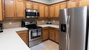 A kitchen with wooden cabinets, a stainless steel refrigerator, a microwave, and a stove. - 4 Bedroom, 2 Bath in Midlothian! Centrally Located, Pet Friendly, Close to Local Wedding Venues. (Midlothian)