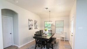 A dining area with a rectangular table, six chairs, a bench, a vase with flowers, and two wall-mounted paintings. - 4 Bedroom, 2 Bath in Midlothian! Centrally Located, Pet Friendly, Close to Local Wedding Venues. (Midlothian)