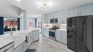 A modern kitchen with light blue cabinets, stainless steel appliances, and a white countertop. - Near Stadiums, Epic Central, Featuring a Private Pool (Grand Prairie)