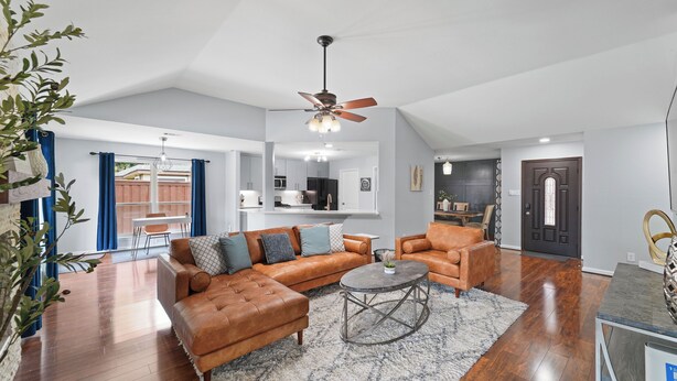 A spacious living room with a brown leather sofa, a round coffee table, and a ceiling fan. - Near Stadiums, Epic Central, Featuring a Private Pool (Grand Prairie)