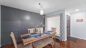 A dining area with a wooden table, chairs, and a vase. - Near Stadiums, Epic Central, Featuring a Private Pool (Grand Prairie)
