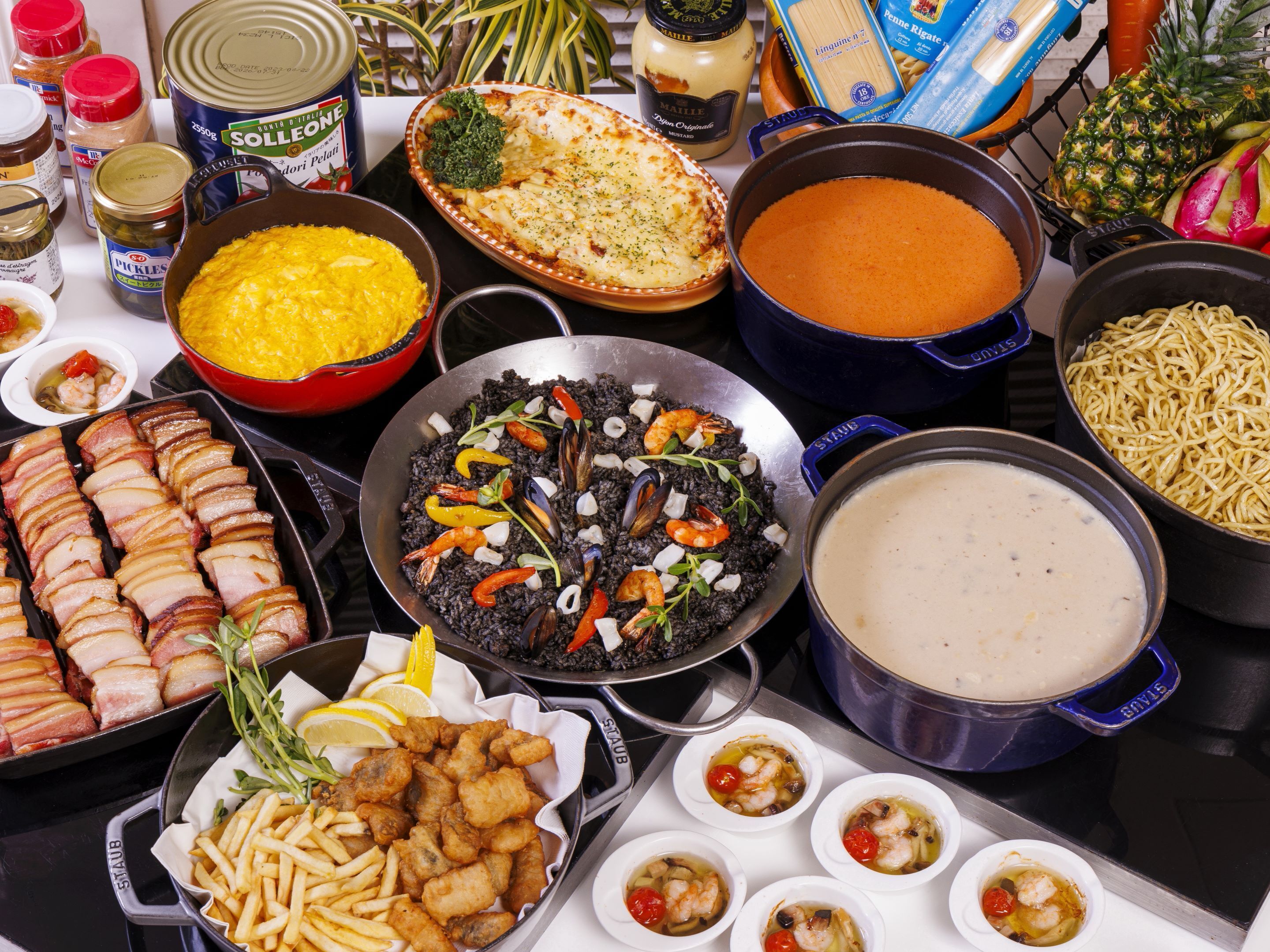 Una variedad de platos, incluyendo mariscos, pasta y pan, que sugiere un servicio de buffet.