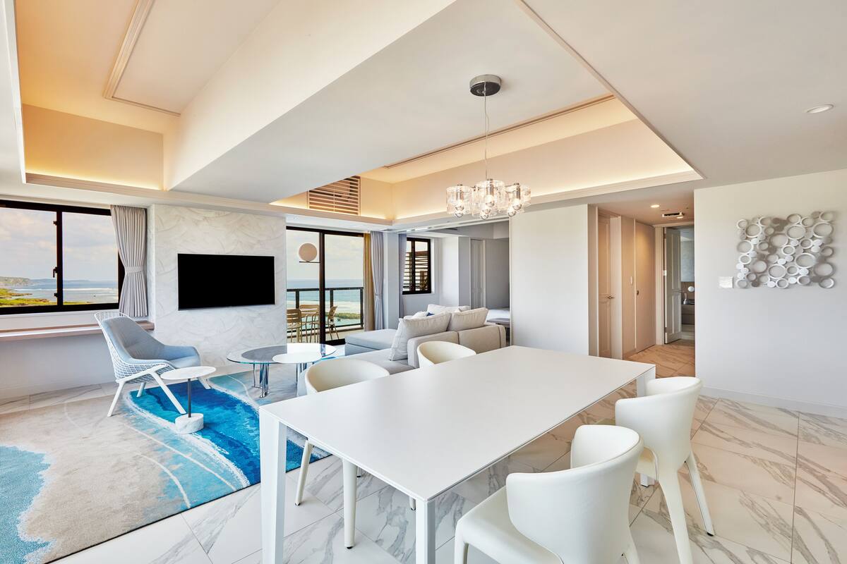 Un vaste espace de vie comprenant une piscine, une table à manger et un coin salon.