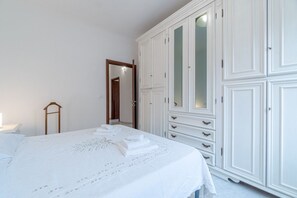 Un dormitorio con cama, armario y espejo.