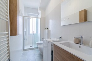 Un baño moderno con ducha, inodoro y lavamanos.