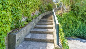 A set of stone steps with a metal handrail, surrounded by lush greenery. - Colle Degli Ometti Vintage Chic Flat x5 (Genova)