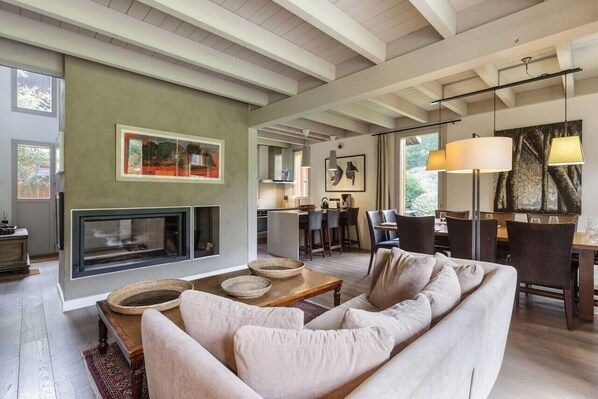 A spacious living area with a fireplace, seating, and a dining area.