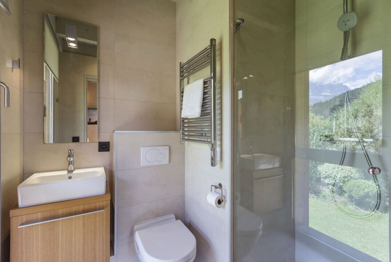 A modern bathroom with a sink, toilet, and glass-enclosed shower.