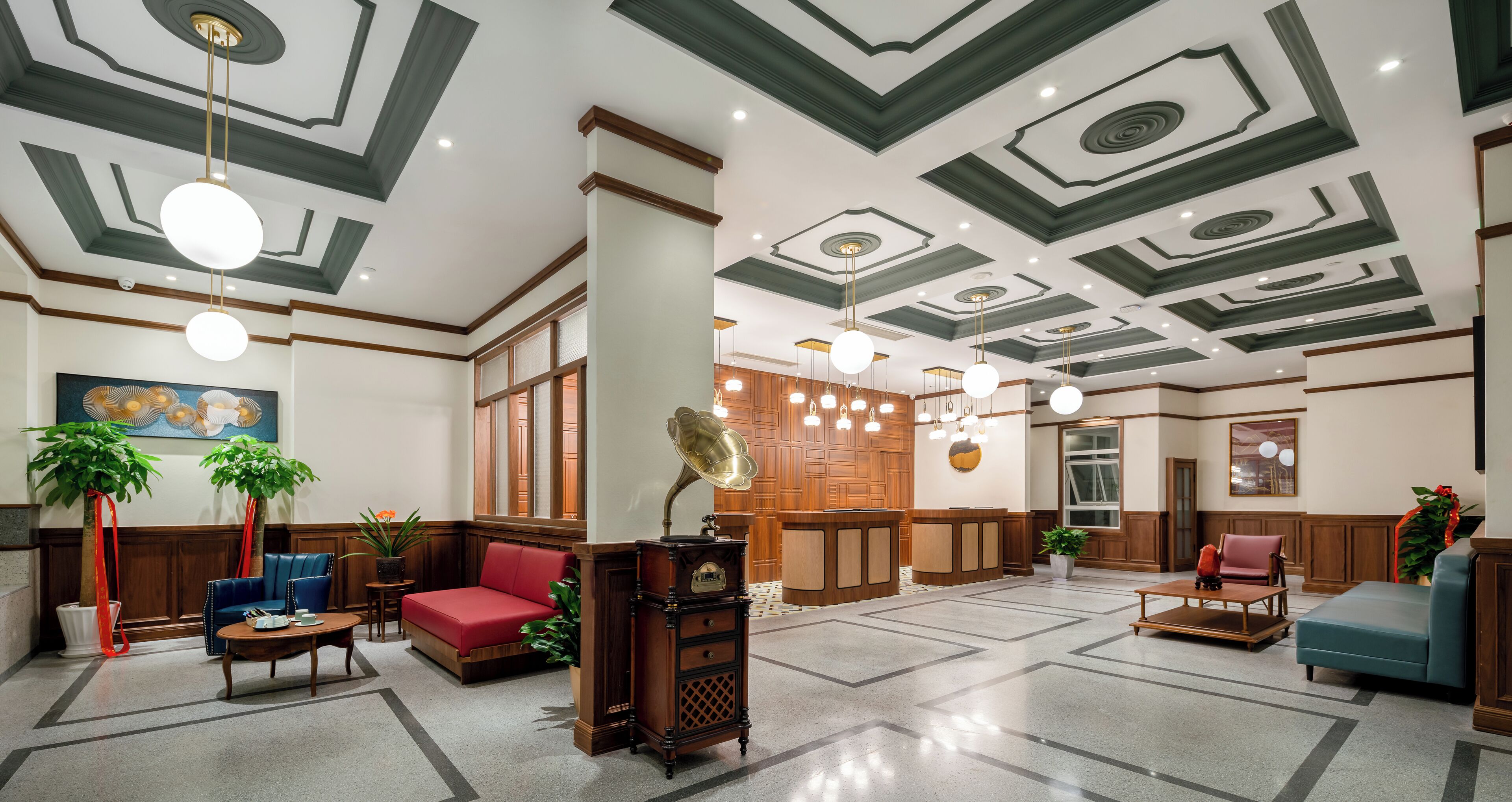 Un hall con mostrador de recepción de madera, zonas de estar y un techo decorativo.
