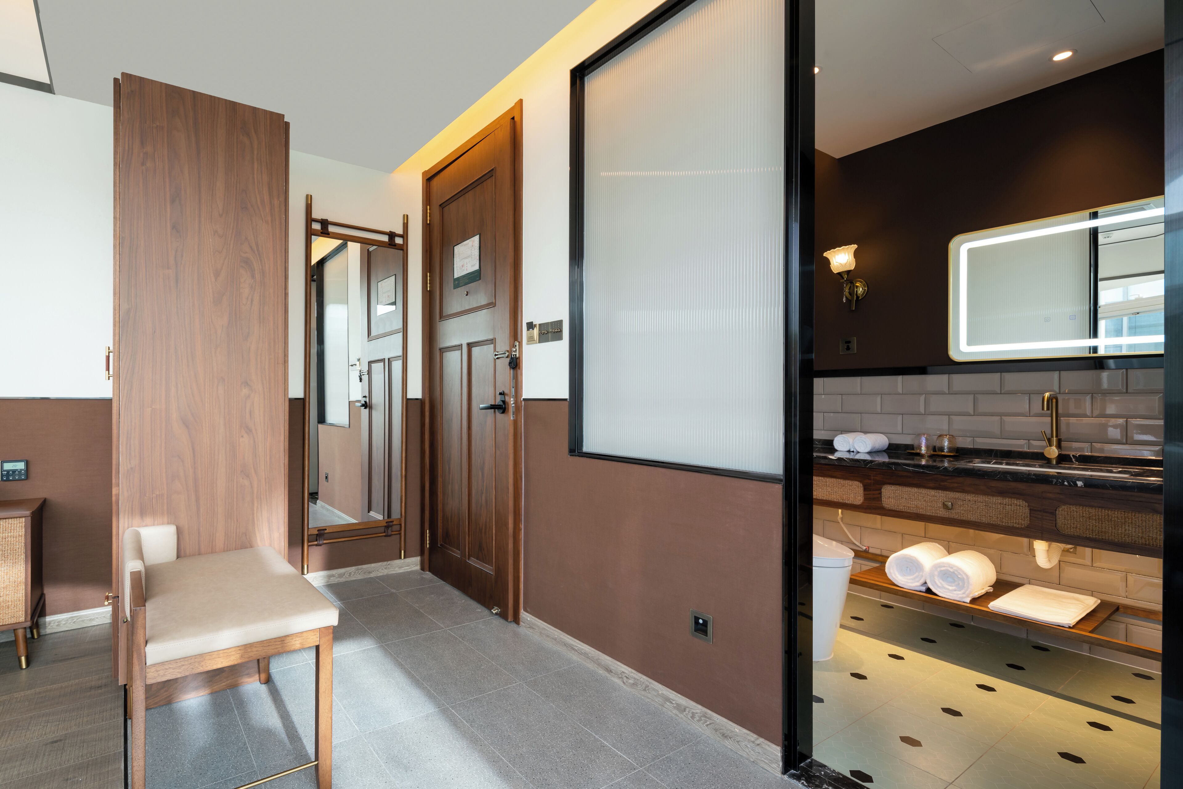 Un baño moderno con un espejo grande, un lavabo y un perchero para toallas.
