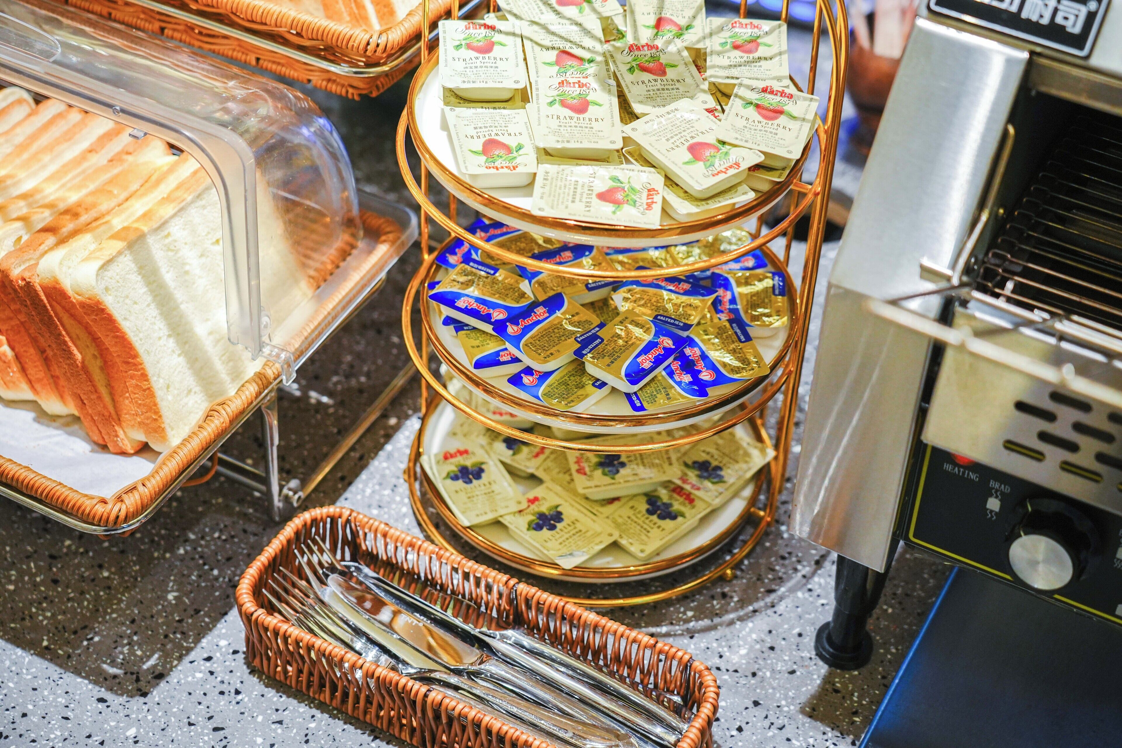 A buffet setup with trays of sandwiches and packets of snacks.