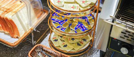 A buffet setup with trays of sandwiches and packets of snacks.