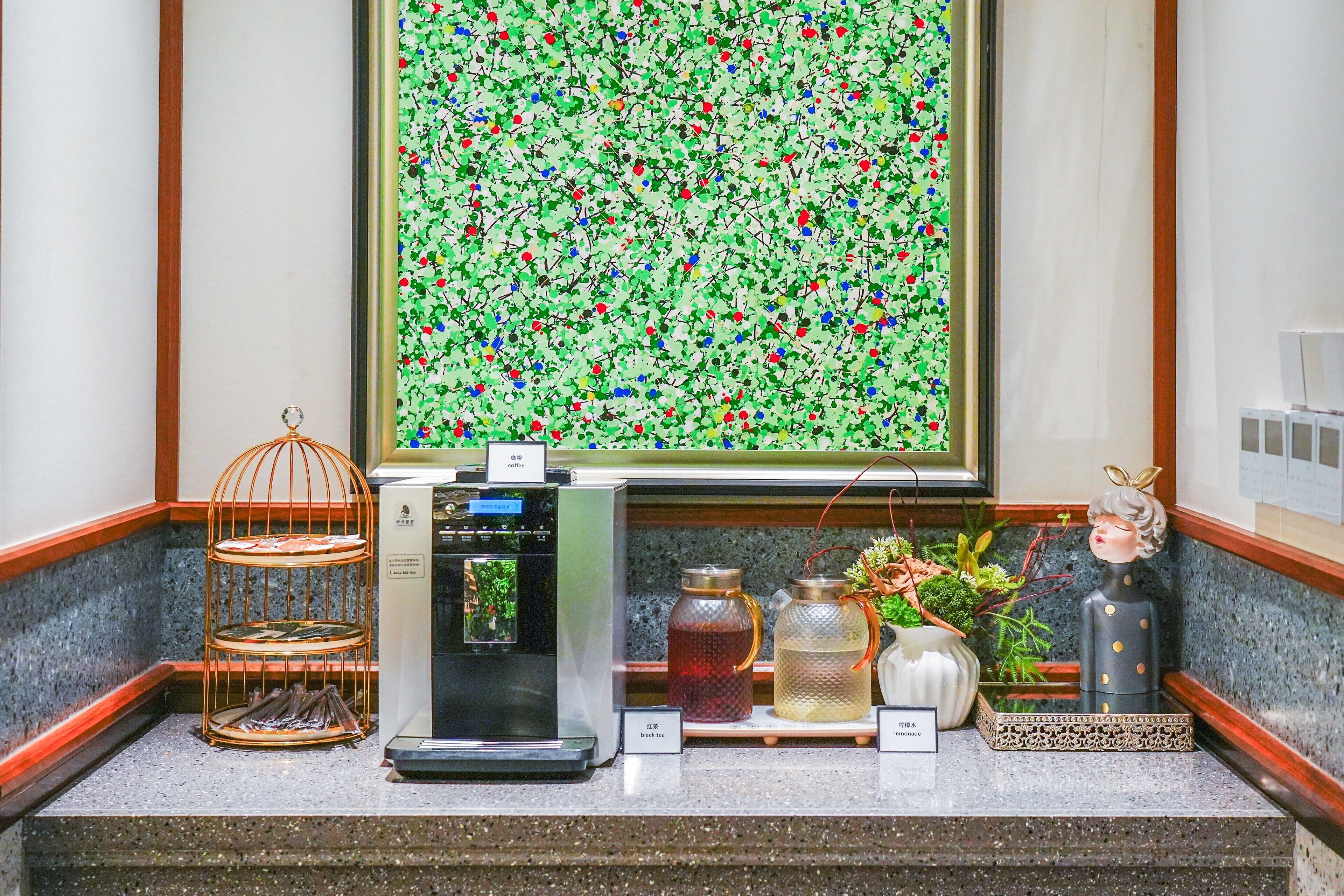 A coffee station with a coffee machine, tea dispensers, and a decorative birdcage.