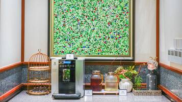 A coffee station with a coffee machine, tea dispensers, and a decorative birdcage.