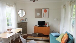 Un espace de vie compact comprenant un coin repas, un canapé, un téléviseur et une cheminée.