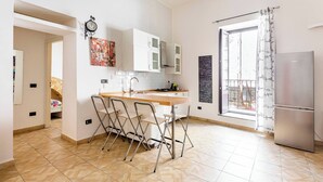 Une cuisine moderne avec un plan de travail en bois, des armoires blanches et un réfrigérateur en acier inoxydable.