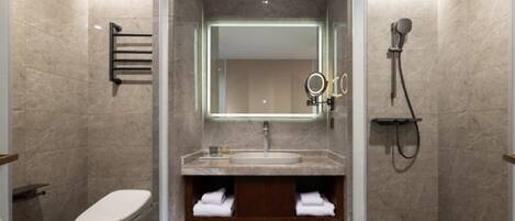 A modern bathroom with a toilet, sink, and shower.
