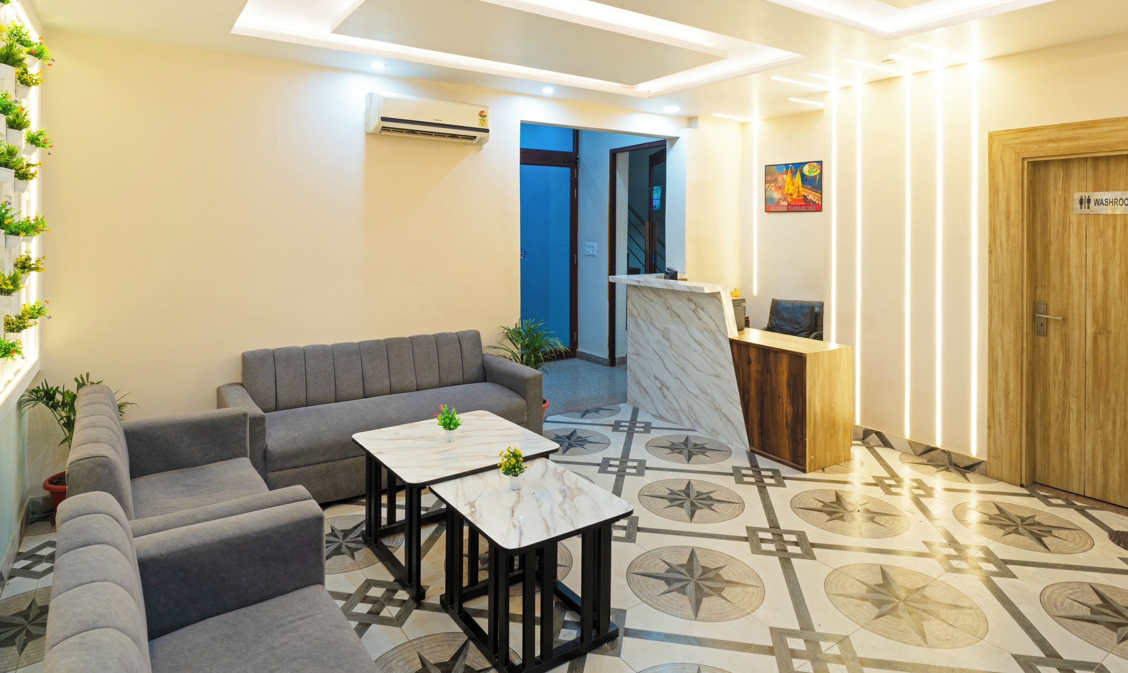 A modern reception area with a sofa, a marble table, and a reception desk.