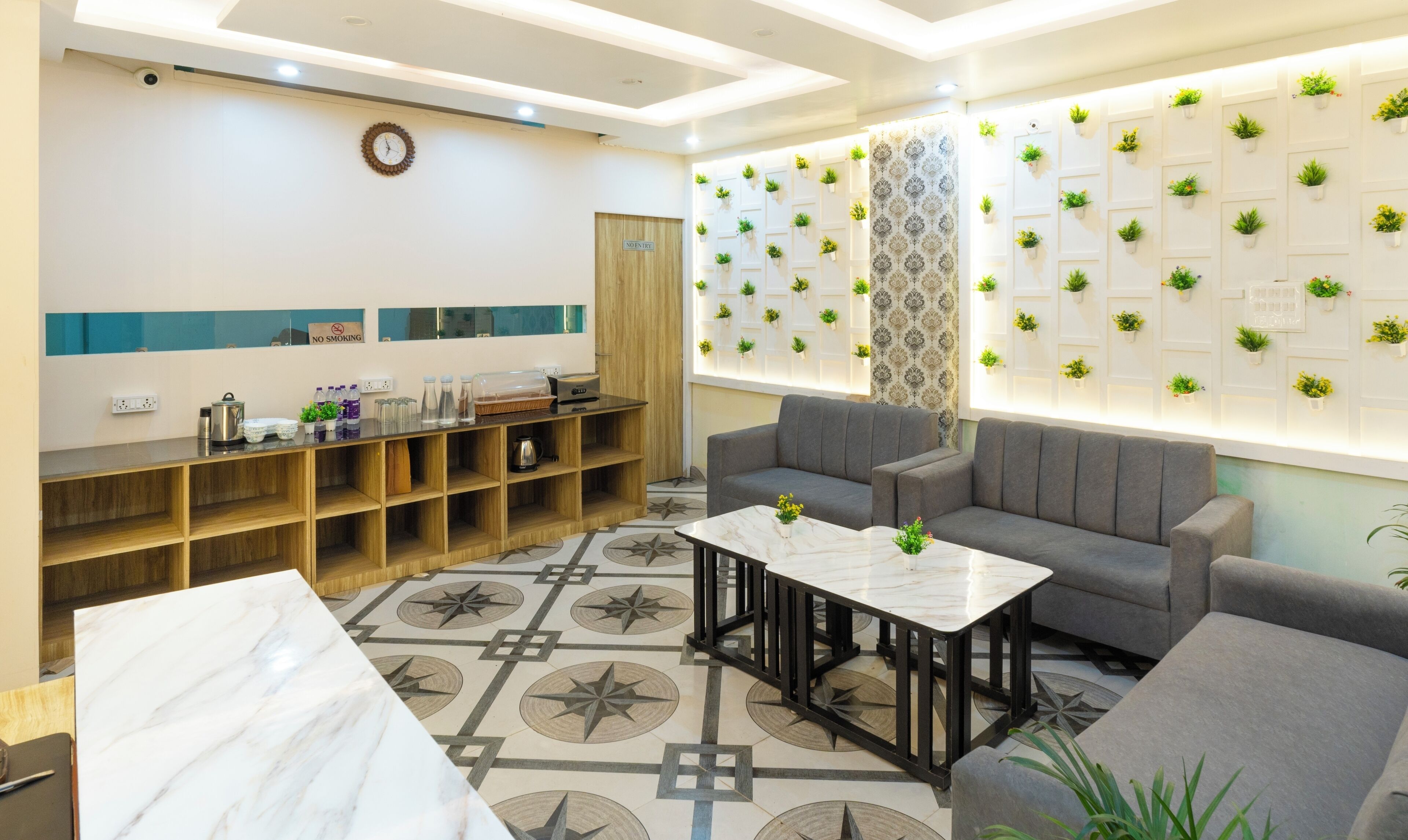 A modern reception area with a wooden reception desk, seating area, and a wall decorated with potted plants.