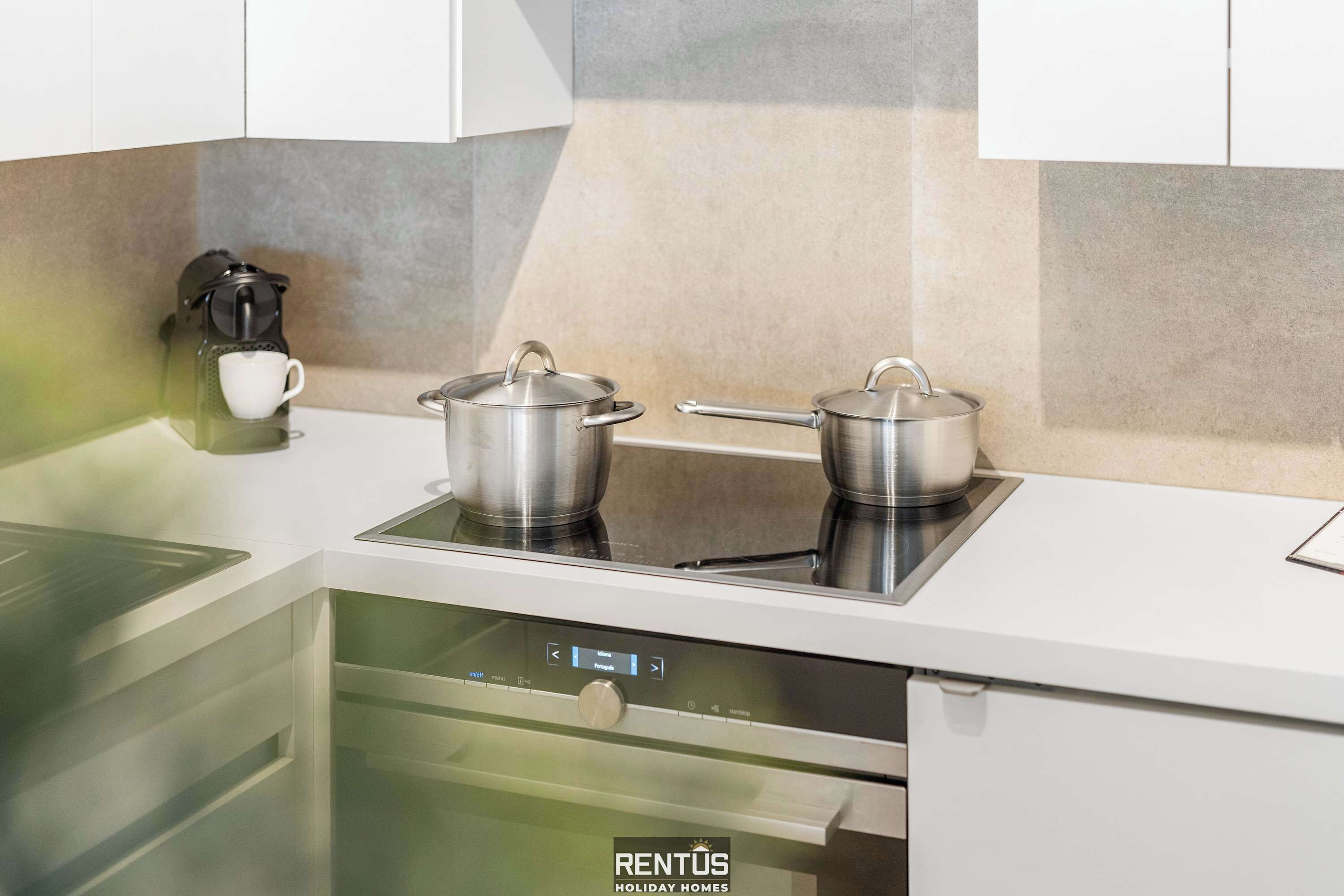 Una cocina moderna con horno empotrado, cafetera y panel de control digital.