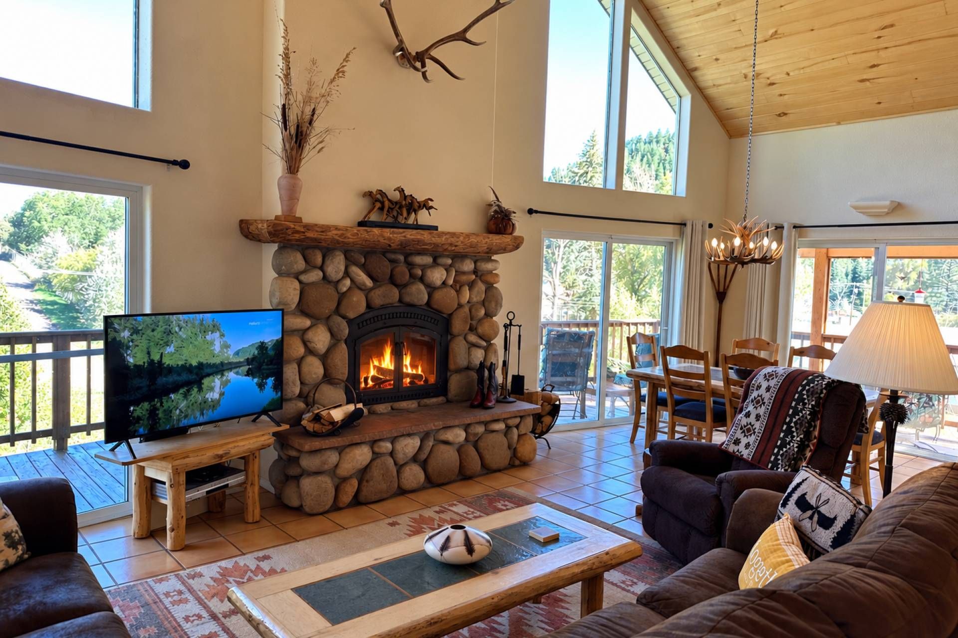 A cozy living room with a stone fireplace, a television, and a comfortable seating area.