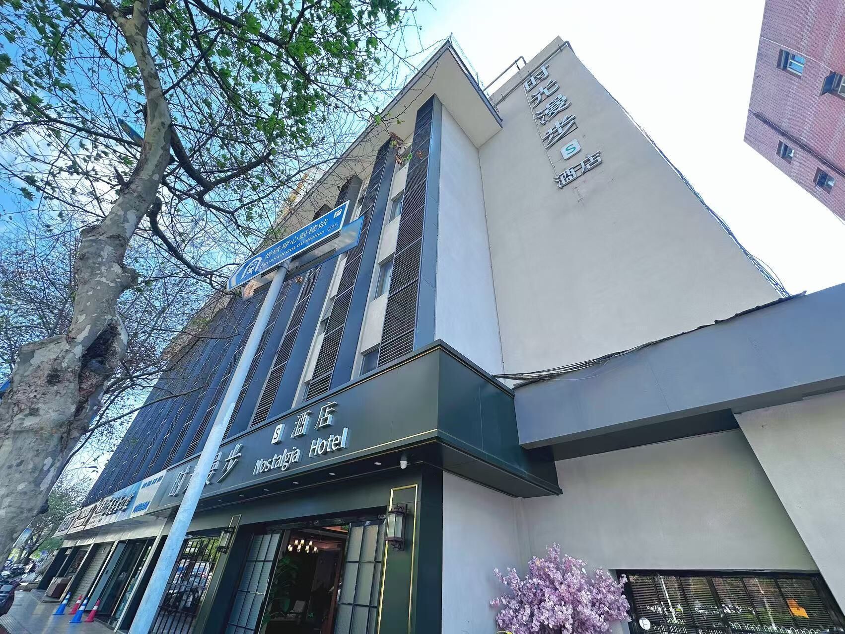 Un bâtiment portant une enseigne indiquant « Nostalgia Hotel », avec une façade moderne dotée de grandes fenêtres et d’une entrée bien visible.