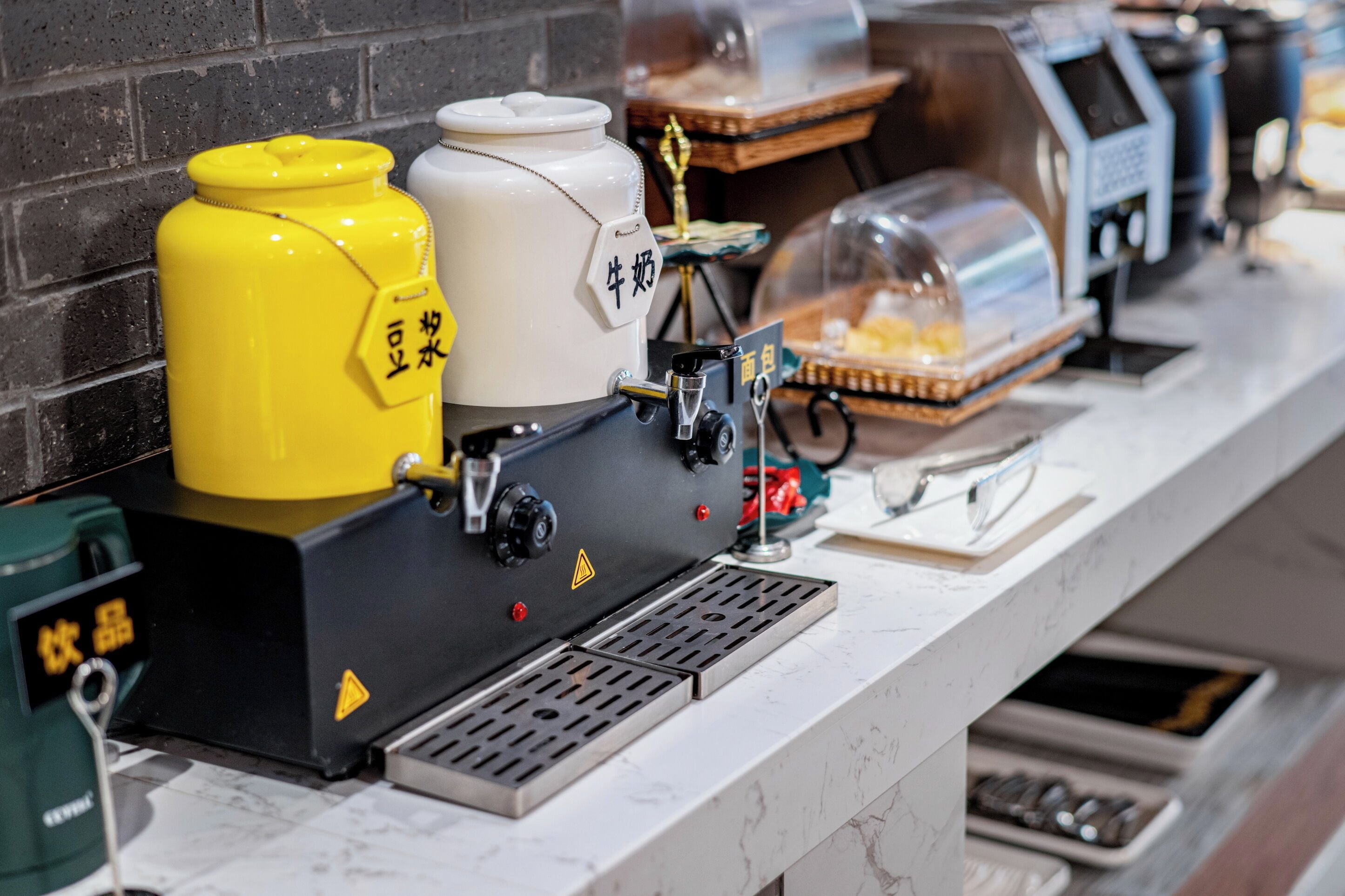Une machine à café dotée d’un récipient jaune et blanc, d’un moulin à café et d’un distributeur de café, le tout posé sur un comptoir en marbre.