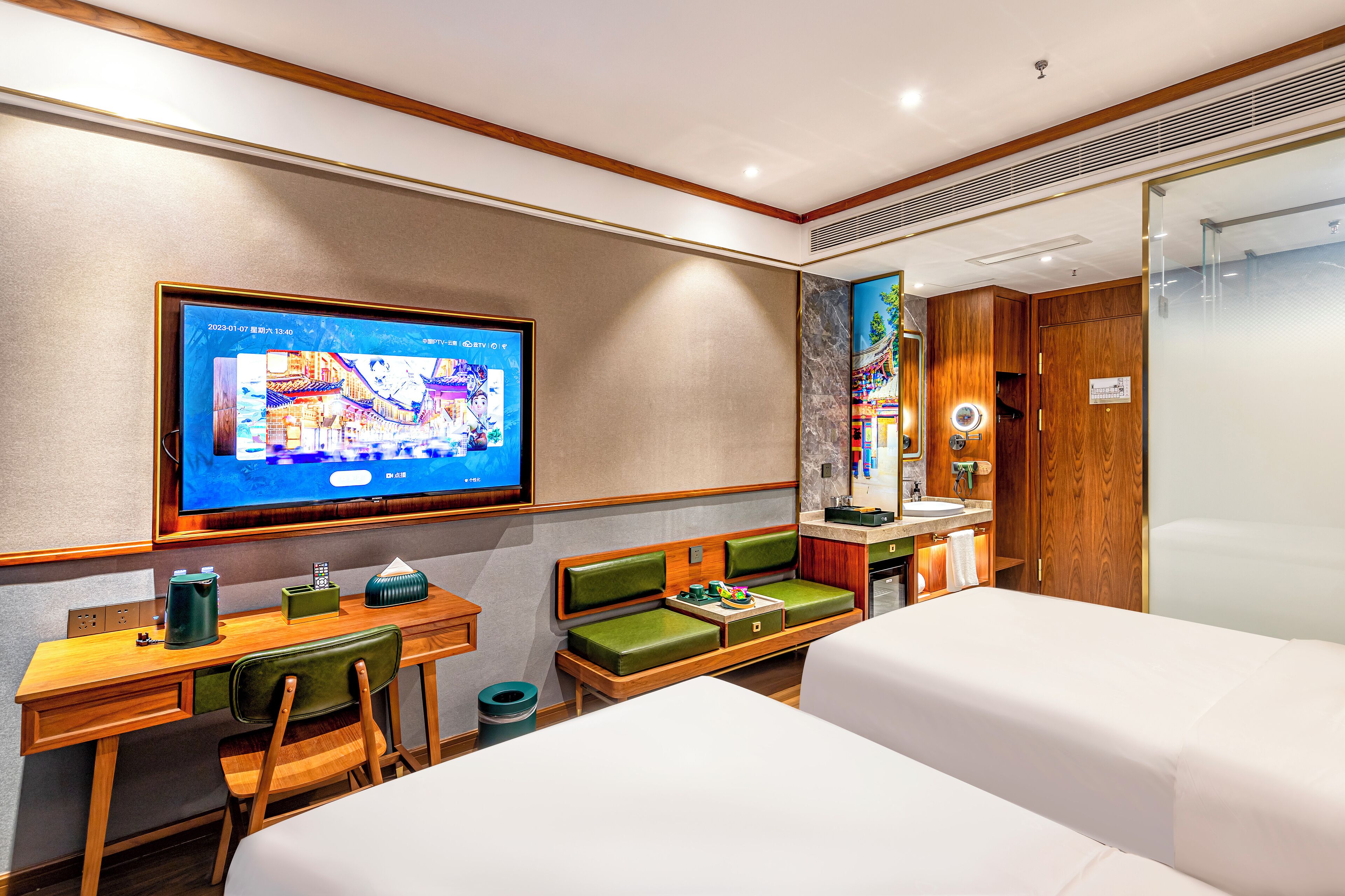 Una habitación de hotel con televisión, escritorio con silla, sofá, cama y baño con espejo.
