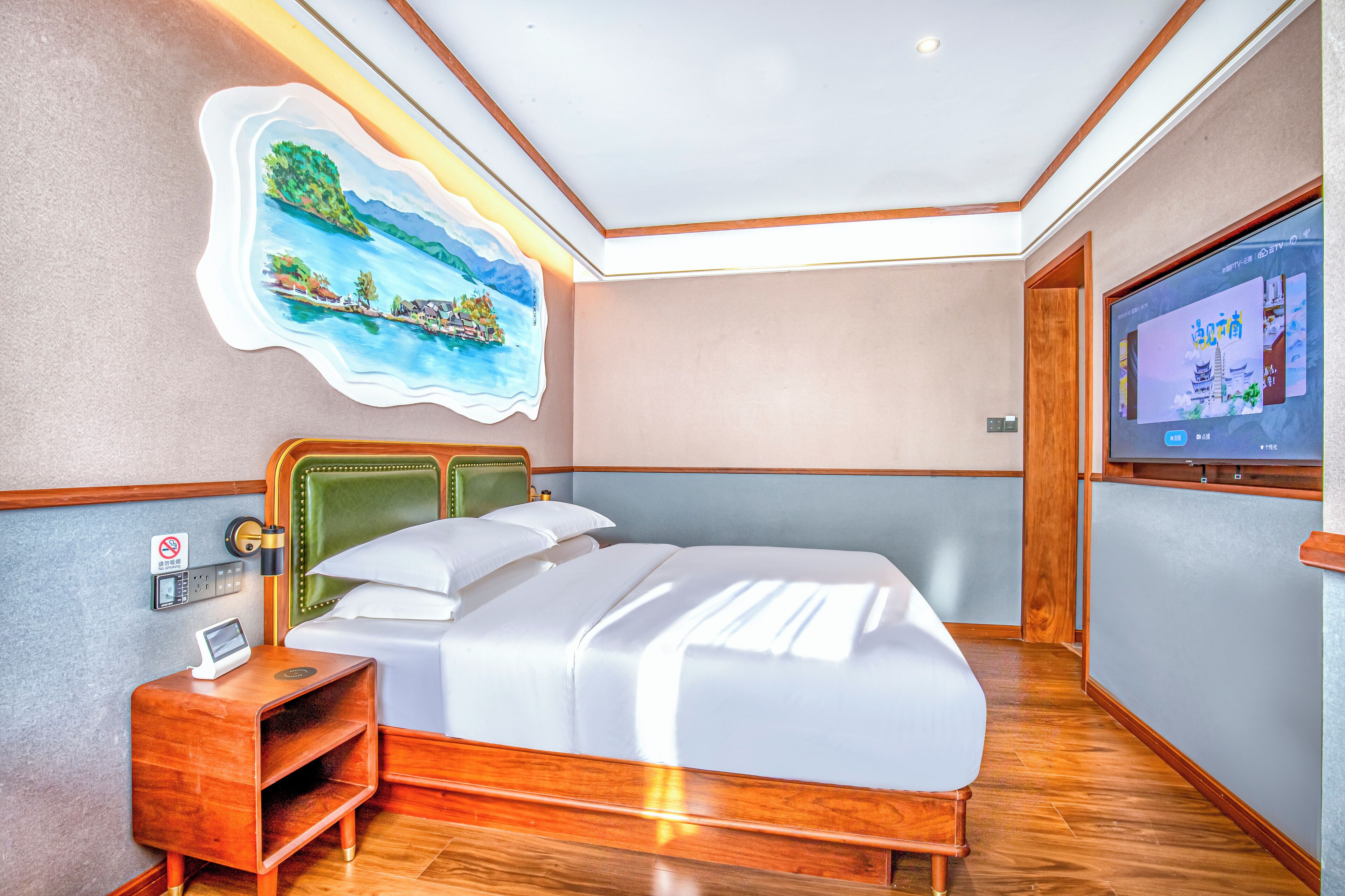 A neatly arranged hotel room with a bed, bedside table, and a wall-mounted TV.