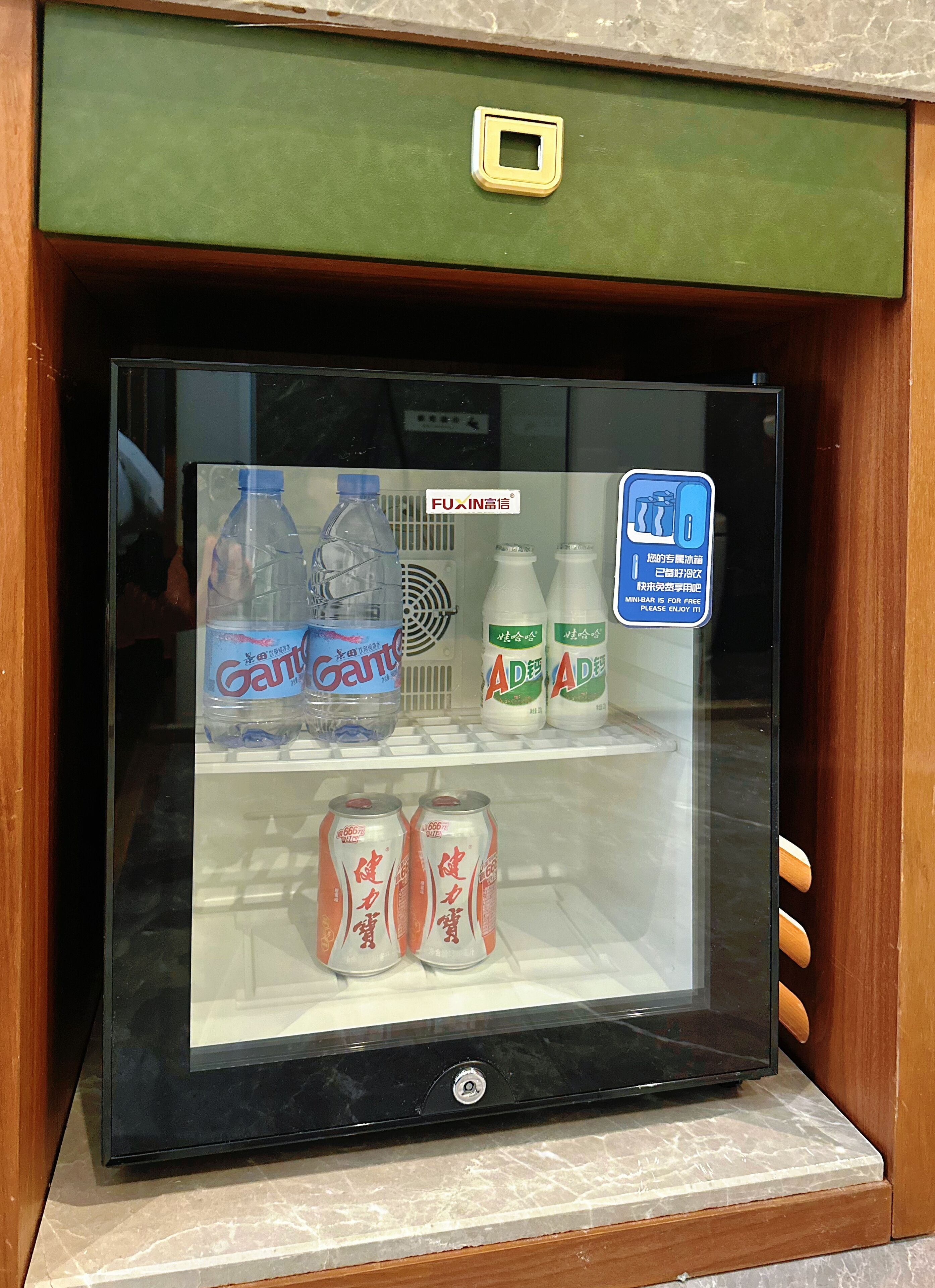 Een automaat met een groene bovenkant, gevuld met flessen Ganten en AD drank, en blikjes van een drankje met Chinese tekens.