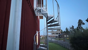 Una escalera de caracol que conduce a un edificio con fachada roja.