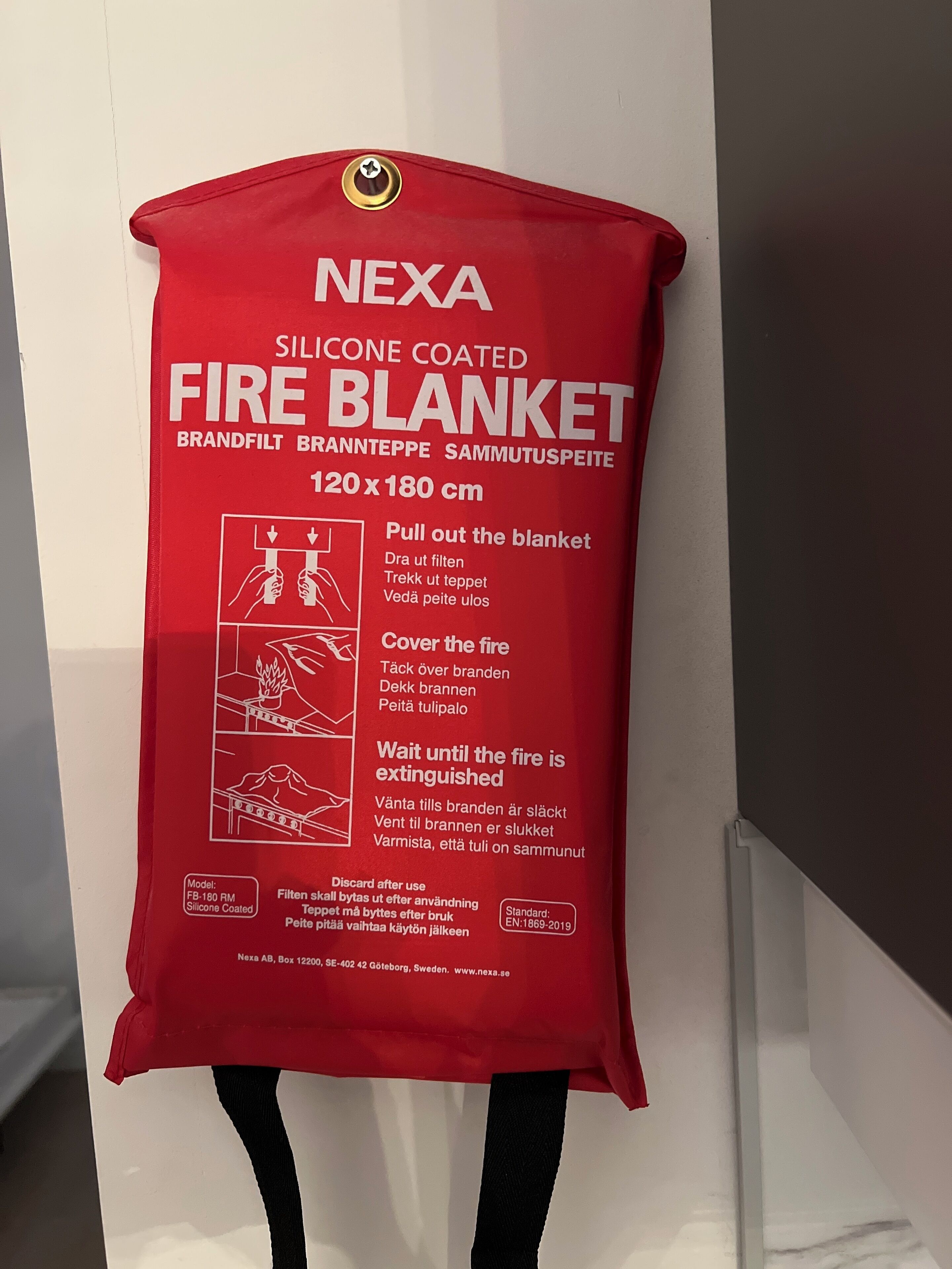 A red fire blanket hanging on a wall.
