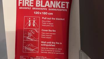 A red fire blanket hanging on a wall.