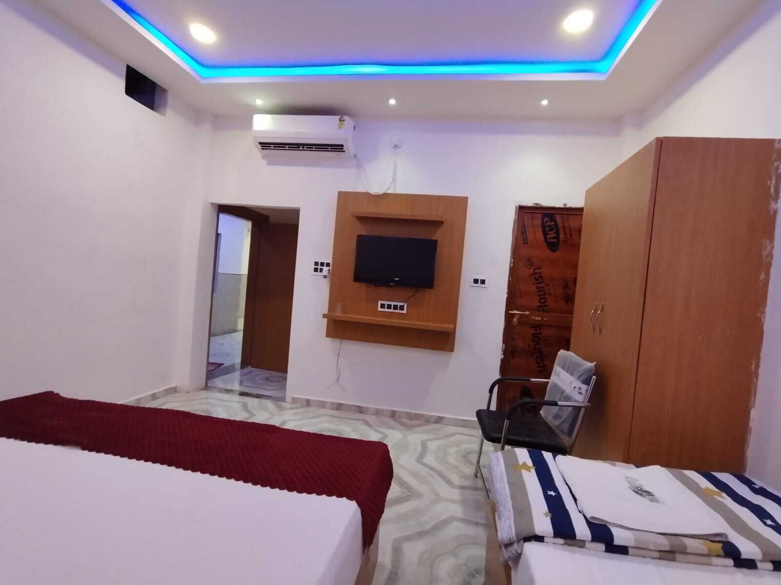 Ein Hotelzimmer mit Bett, Wandfernseher, Kleiderschrank und Stuhl.